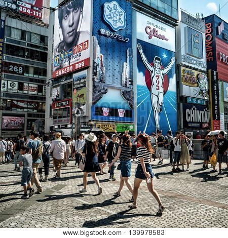 Osaka - July 2016: Street view with people and famous Glico running man billboard in backgorund. Dotonbori 