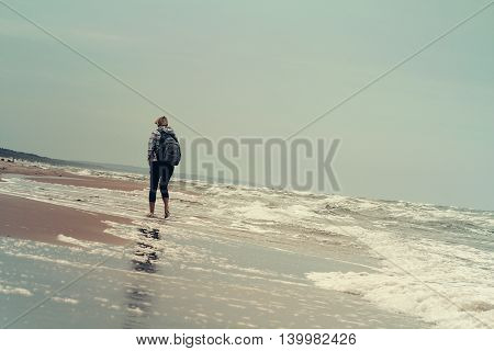 Young Woman Walking On The Sea Waves