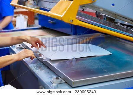 Serigraphy print bags machine in printing factory with operator female hand