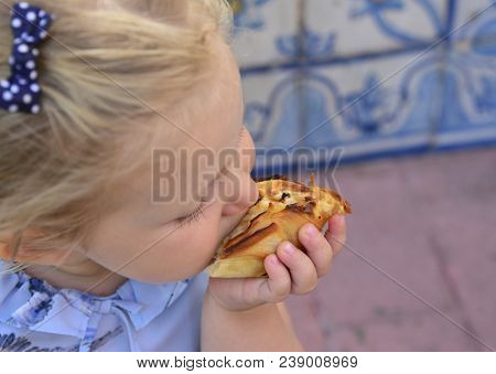 The Girl Is Eating Pasteis De Belem Egg Tart. Azulejos Tile On A Background