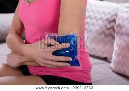 Close-up Of A Woman Applying Cool Gel Pack On Her Elbow