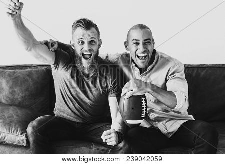 White men cheering sport together at home