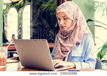 Islamic woman sitting and using laptop