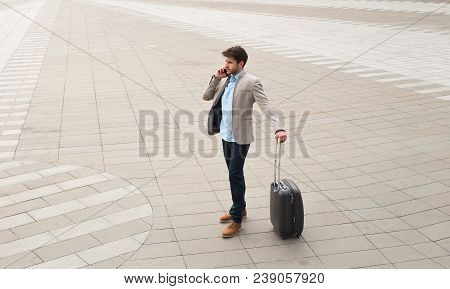 Strategic Thinking! Handsome Young Businessman With His Luggage Standing And Talking On Phone At The