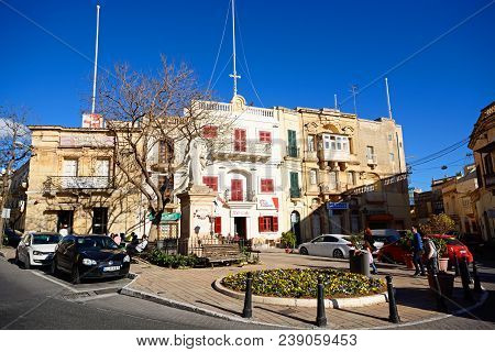Naxxar, Malta - April 2, 2017 - Statue Of Madonna And Child In The Pjazza Vittorja With The Red Cafe