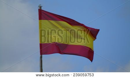 Spanish Flag Blowing On The Wind With Blue Background