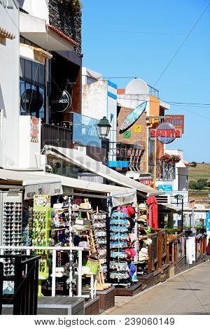 Alvor, Portugal - June 7, 2017 - View Along A Village Street With Shops And Restaurants Leading Towa