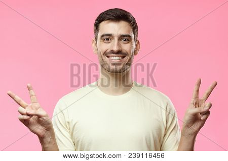 Closeup Photo Of Young Positive European Man In Beige T-shirt Isolated On Pink Background Feeling Pe