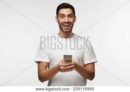 Horizontal Photo Of Young Good-looking European Man Isolated On Grey Background Standing In White T-