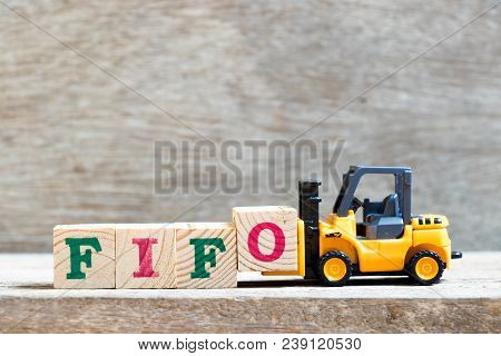 Toy Forklift Hold Letter Block Fifo (abbreviation Of First In First Out) To Complete Word  On Wood B