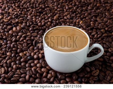 Cup Of Coffee With Milk On Background Of Coffee Beans