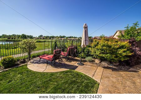 Two Patio Lounge Chairs Overlooking Pond And Field