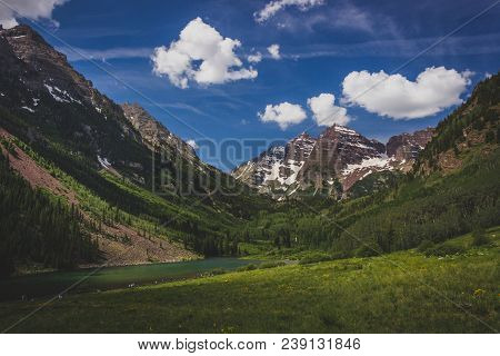 Majestic Maroon Bells Peaks And Maroon Lake On A Sunny Day And Blue Sky In Summer Near Aspen, Colora