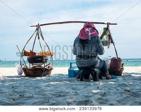 Asian Food Vendor Sitting At The Beach Selling Chicken