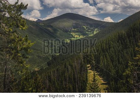 Tree-covered Vail Mountain With Blue Skies And Shadows Cast From The Clouds Above On A Summer Day In