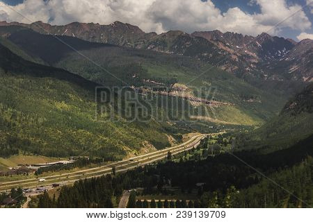 Tree-covered Vail Mountain With Blue Skies And Shadows Cast From The Clouds Above On A Summer Day In