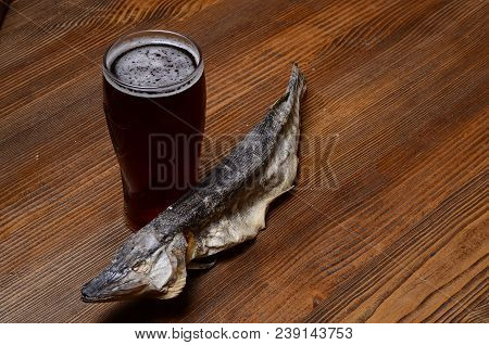 Beer With Dried Fish And Snacks On Wooden Table.