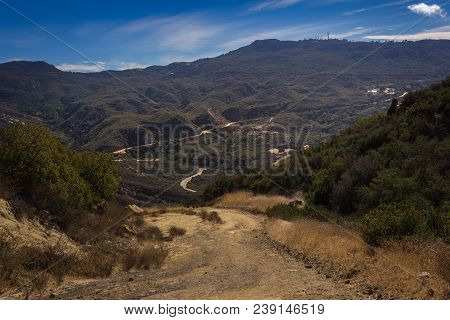 Picturesque Overlook Of Calabasas Peak Trail Winding Through The Canyon With Rock Formations On A Su