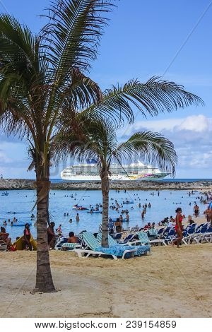 Tourists Enjoying Sunny Weather In Bahamas With Cruise Ship In Background