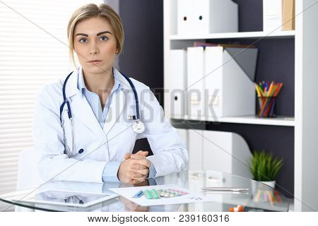 Woman Doctor Write Prescription While Sitting In Hospital Office. A Lot Of Various Colored Pills Liy