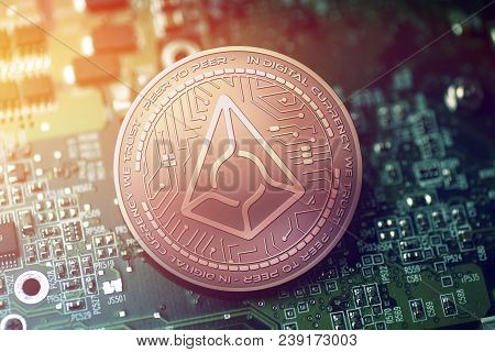 Shiny Copper Augur Cryptocurrency Coin On Blurry Motherboard Background Token