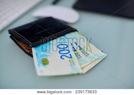 200 Shekels In A Leather Purse On A Working Glass Table.