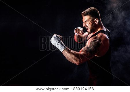 Sport Concept. Sportsman Muay Thai Boxer Fighting On Black Background With Smoke. Copy Space.