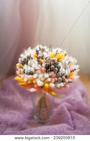 Wedding Rings On Bouquet Of Dry Flowers