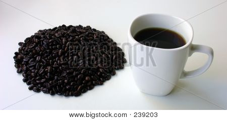 Kahve çekirdekleri ve bir kupa kahve