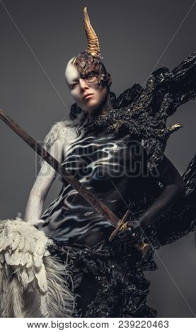 Portrait Of Devil Woman In Black And White Clothes With One Horn On Her Head. Isolated On Grey Backg
