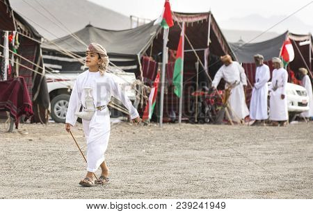 Ibri, Oman, 28th April 2018: Young Omani Boy Walking In Front Of Bedouin Tents At A Local Nteve