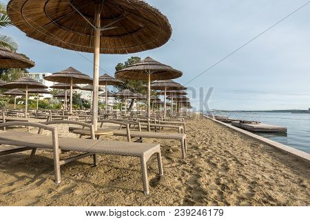 Beach With Beach Chairs In Morning Light On The Beach Of A Croatian Seaside Holiday Resort In Porec,