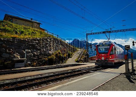 Poschiavo, Grisons, Switzerland - August 10, 2016 : Red Train Of The Rhaetian Railway Entering The S