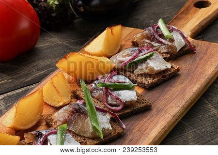 Herring With Baked Potatoes And Onions On Tray On Wooden Background. Restaurant Dish