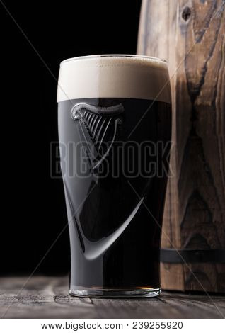 London, Uk - May 03, 2018: Original Glass Of Guinness Draught Stout Beer Next To Wooden Barrel On Da