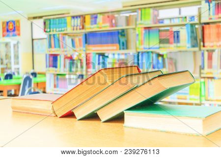 Old Book Red - Green. And Heap Treatise In School Library On Wooden Table.  Blurry Bookshelves Backg