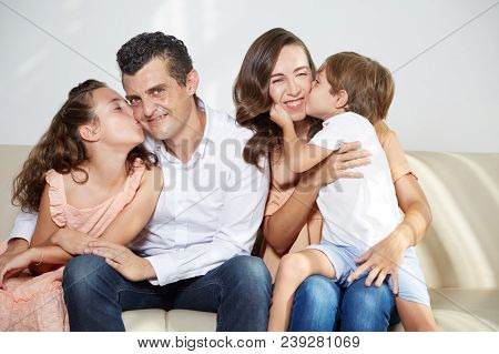 Joyful Children Kising Their Parents On Cheeks