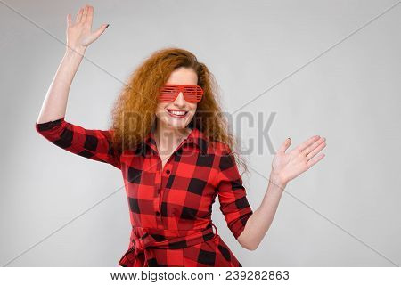 Charming Young Girl In A Checkered Cloth On A Gray Background
