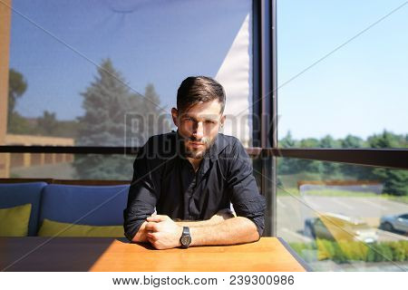 Young Businessman Sitting At Office On Sofa And Wearing Black Shirt. Concept Of Responsibility And S