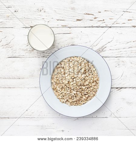 Oatmeal, Rolled Oats On White Wooden Background Wilt Glass Of Milk. Porridge Oats, Used In Granola O