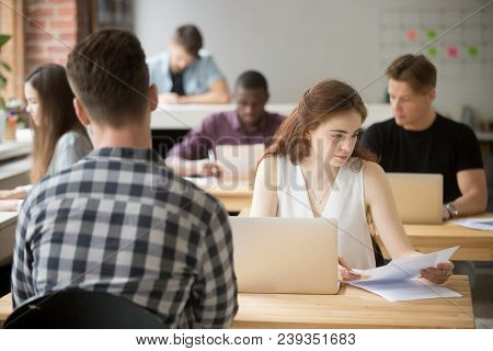 Concerned Female Worker Reading Paper Report Checking Data And Statistics On Laptop In Coworking Off