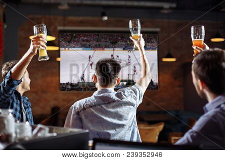 Happy Fans. Three Friends Watching A Game At The Pub.
