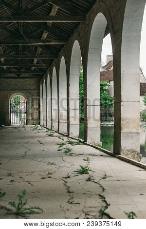 Arch Along The Building,  A Long Cracked Cement Path
