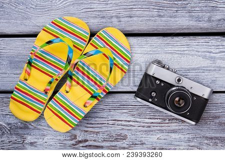 Travel And Vacation Items On Wooden Table. Flip Floppers And Photo Camera. Top View With Copy Space.