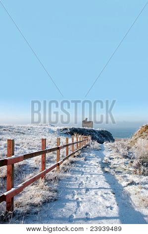 Fenced เดินไปปราสาท Ballybunion ในหิมะ