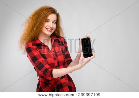 Charming Young Girl In A Checkered Cloth On A Gray Background
