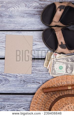 Summer Clothes And Accessoires With Beige Paper. Top View, Flat Lay. Woolden Desk Surface Background