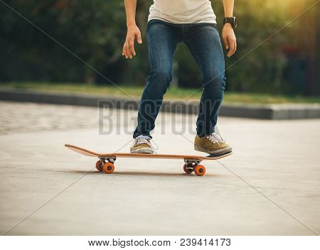 One Woman Skateboarder Sakteboarding On Parking Lot