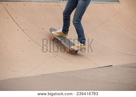 One Woman Skateboarder Sakteboarding On Skatepark Ramp