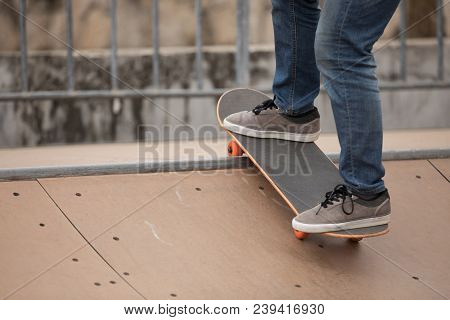 One Woman Skateboarder Sakteboarding On Skatepark Ramp